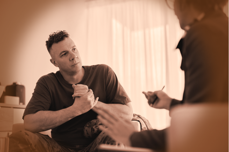 a woman speaking to a man in a therapy session