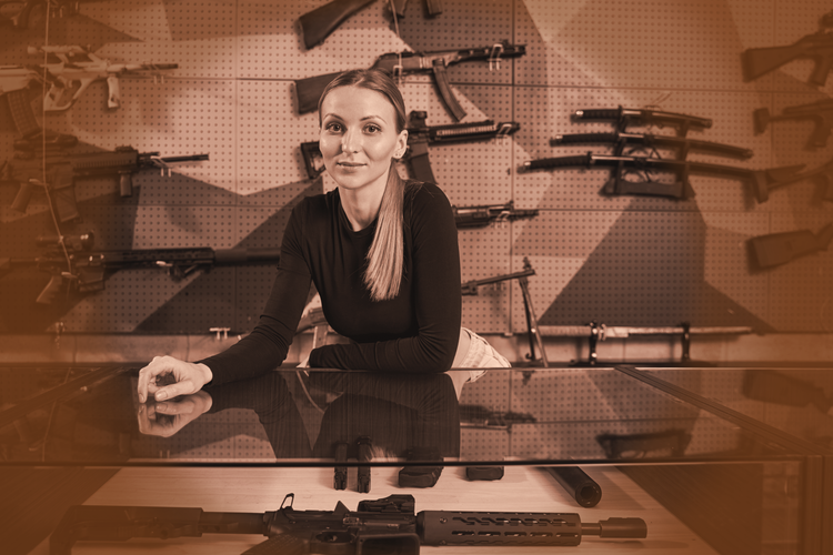 a woman standing behind the counter of a gun shop