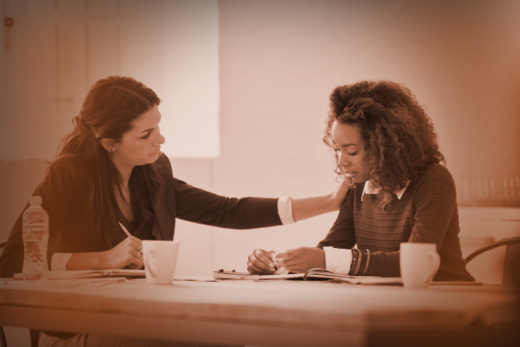a woman consoling another woman